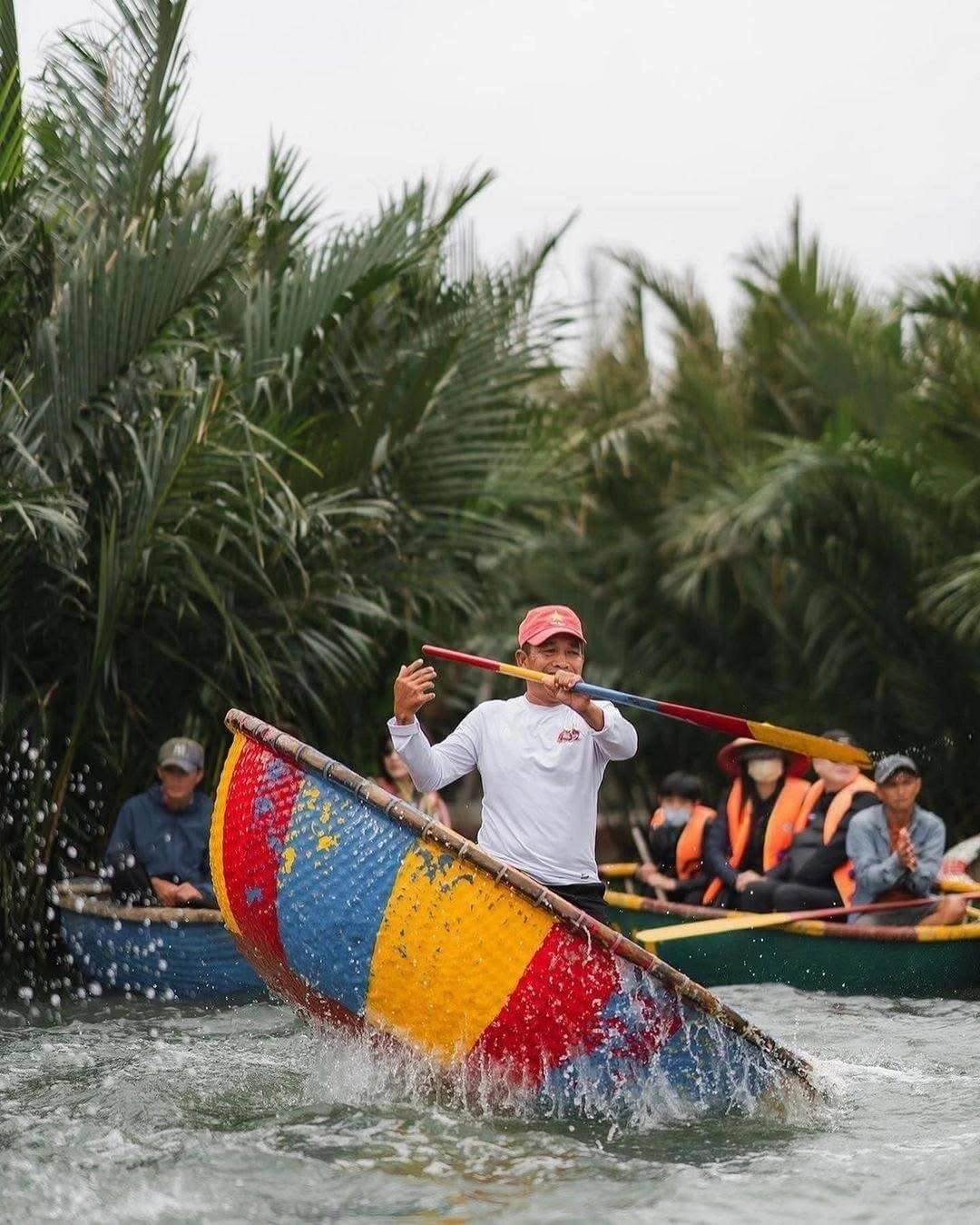 Boatmen performing folk dance on basket boat Hoi An